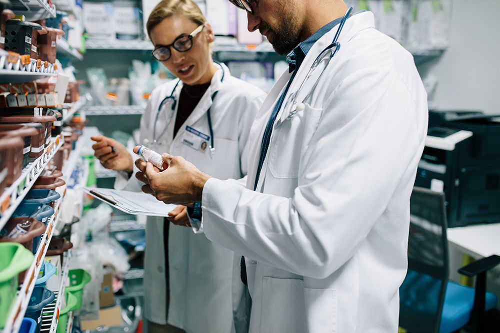 Male and female pharmacists checking inventory at pharmacy